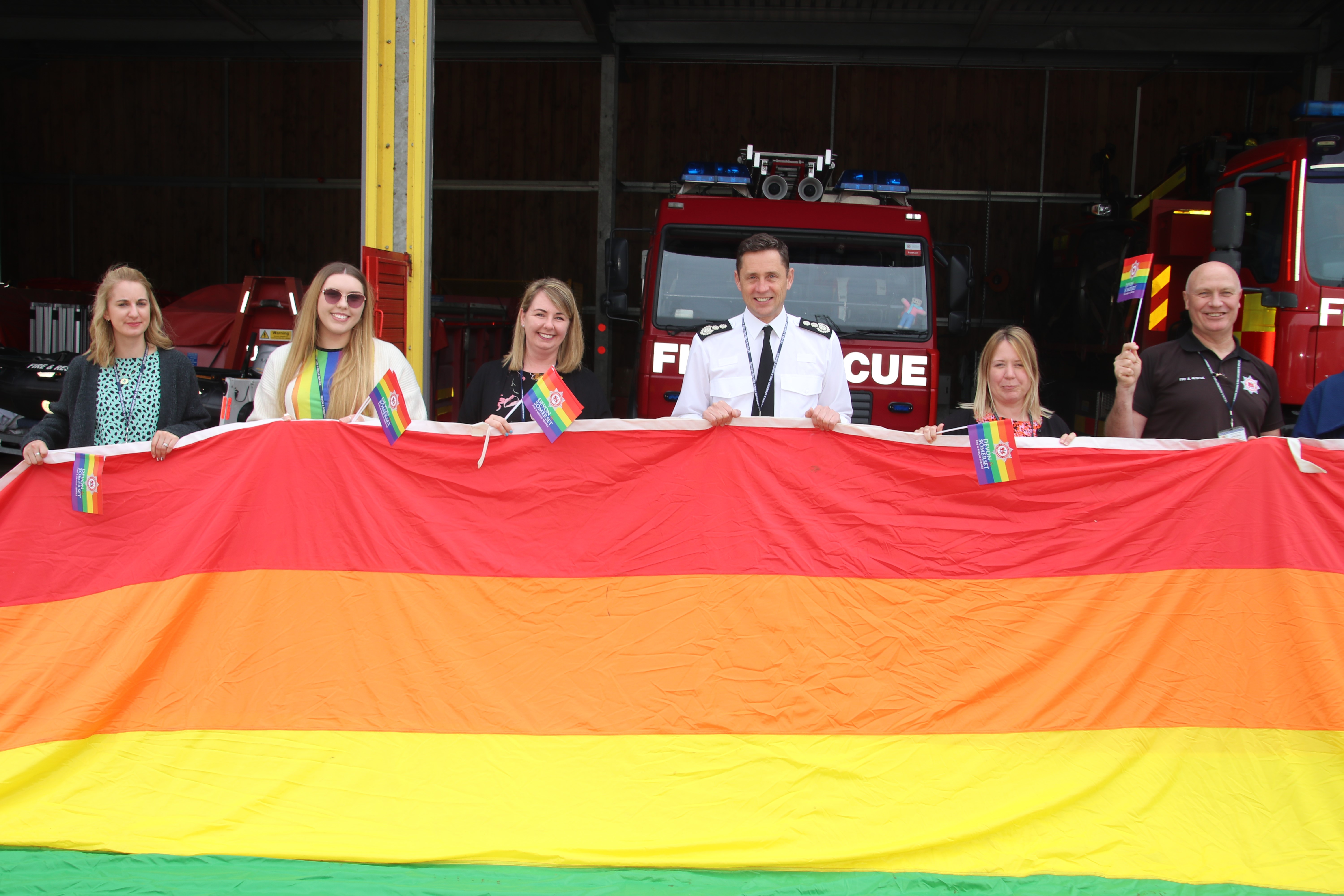 The Chief Fire Officer and colleagues with the flag