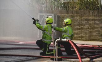 Two firefighters spraying water
