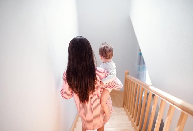 woman carrying baby down stairs